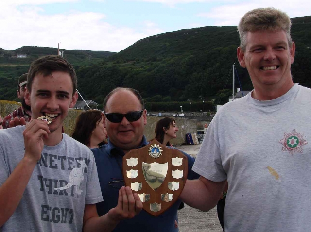 Noel presents Cathal and Kevin with the seniors' winning shield. Photo: MB